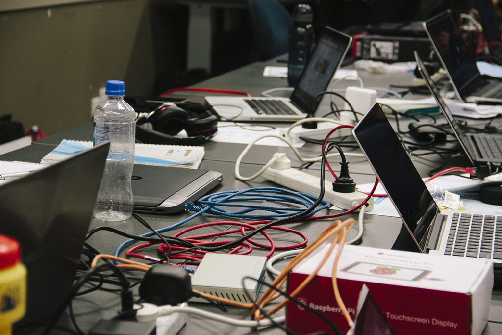 An image of laptops, cords, and other various technology on a table